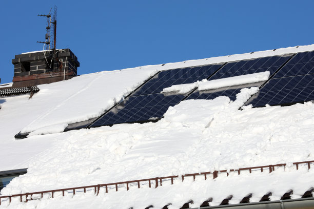 太阳能电池板在冬天部分被雪覆盖图片下载