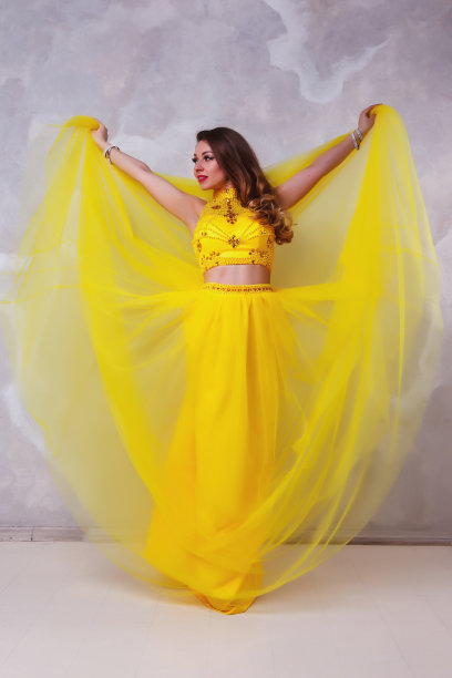 漂亮的女士在长舞台黄色连衣裙肖像纹理白色墙壁图片下载