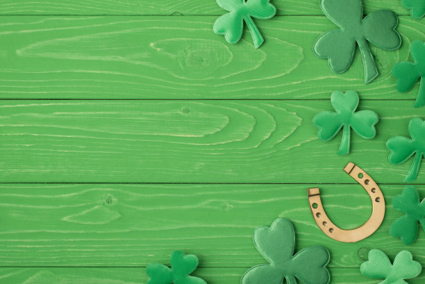 圣帕特里克节庆祝概念。头顶上方近距离观看照片图像的金色马蹄铁和三叶草叶子孤立的亮颜色绿色桌子桌子与广告的拷贝空间图片下载