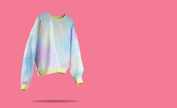 粉红、黄色、蓝色系带染料漂浮在粉红色背景上的女性帽衫。创意服装理念，时尚舒适的毛衣。女装秋春季打折。“黑色星期五”。蓝色星期一购物图片下载