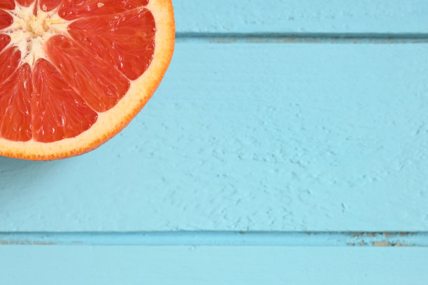 红色葡萄柚，切成两半，背景是乡村的蓝色木头图片下载