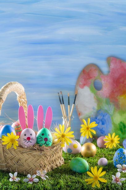 草地上的复活节篮子里放着复活节彩蛋，蓝色的墙上挂着春天的雏菊花图片下载