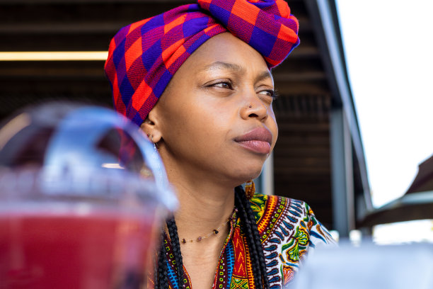 一幅沉思的非洲妇女盯着户外的东西的特写图片下载