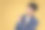 快乐的年轻亚洲人的肖像，穿着随意，手指在copyspace。黄色背景图片下载