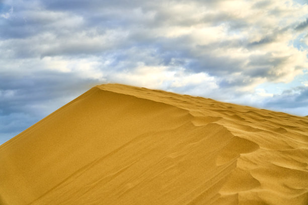沙漠。沙丘。蓝天白云。鸟在日落时分。山脉。天空。图片下载