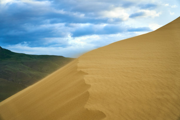 沙漠。沙丘。蓝天白云。鸟在日落时分。山脉。天空。图片下载