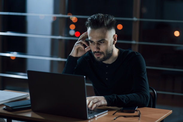 想睡觉。时髦的年轻商人晚上独自在办公室工作图片下载