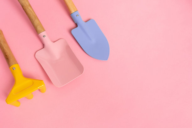 一套照顾花园的设备，三个园艺工具在粉红色的背景和复制空间。春季和园艺概念。为博客或网站提供照片图片下载