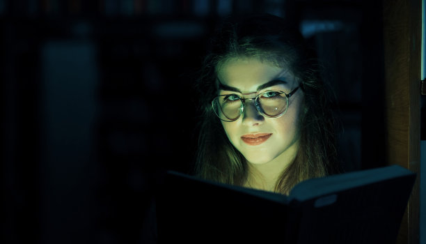 神秘的绿光来自于这本书。创造力的概念。女学生在图书馆。教育的概念图片下载