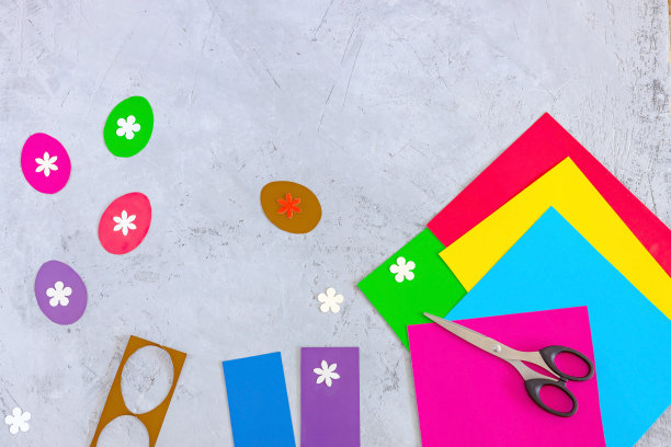 剪刀，彩纸，在混凝土背景上剪出鸡蛋和花朵图片下载