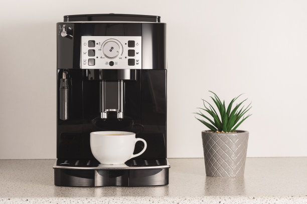 厨房里有一台带杯子的现代浓缩咖啡机。图片下载