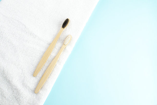 白色的毛巾和竹制的牙刷在浅蓝色的背景和复印空间。生态学的概念。图片下载