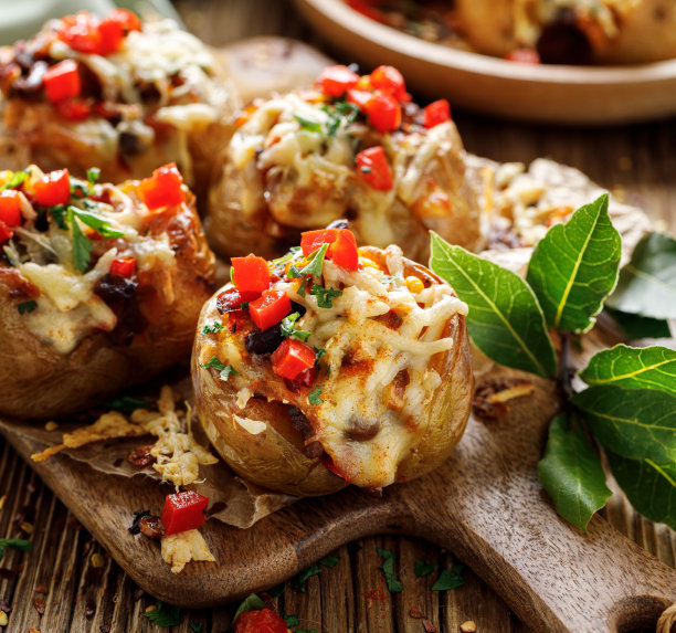 墨西哥风格的烤土豆与辣椒牛肉馅和奶酪在黑暗的背景近景图片下载