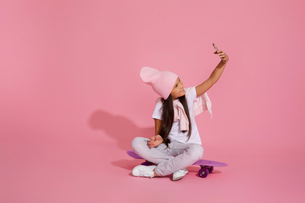 小女孩坐在滑板上自拍图片下载