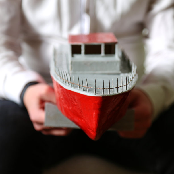 一个年轻人手里拿着一艘临时搭建的游艇。在一个男人的手里图片下载