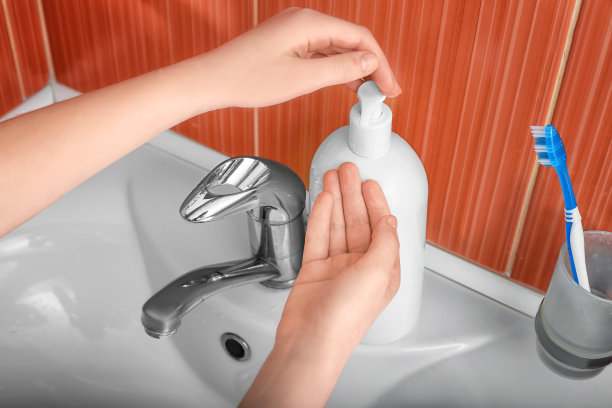 用手在贝壳的背景上涂抹杀菌剂。图片下载