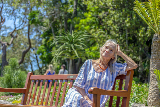 现代的肖像，迷人的，妇女坐在公园在阳光明媚的日子，背景与复制空间图片下载