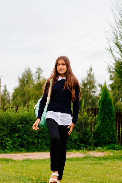 一个十几岁的女孩背着公文包去上学。图片下载