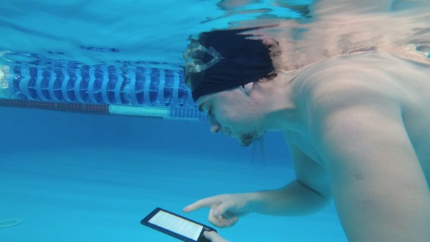 人们在水下读电子书。特殊防水电子装置。你可以在水下直接阅读文本和显示标志。图片下载