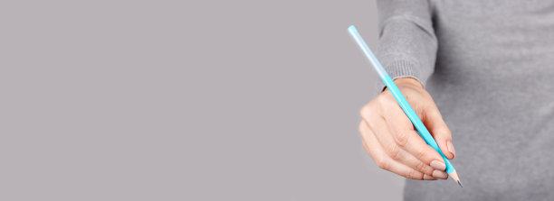 手用蓝色铅笔在灰色的背景。图片下载