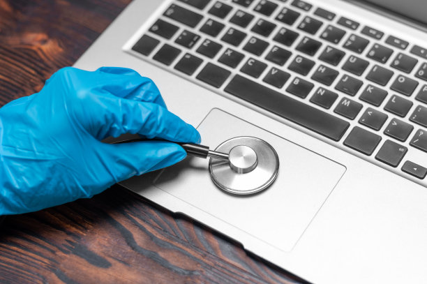 戴医用手套的手部照片：技术员用听诊器检查笔记本电脑，电脑维修店概念图片下载