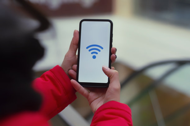 超市免费上网。一名女子拿着一台智能手机的模型，白色屏幕上有一个图标，背景是商场里的自动扶梯。图片下载