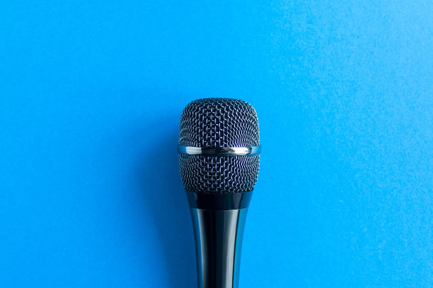 麦克风在一个彩色的蓝色背景接近。唱歌，写音乐，网上卡拉ok，创意，声乐概念，符号。歌唱课图片下载