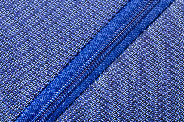 蓝色拉链的衣服，袋子的服装生产。拉链卷塑料对角线图片下载