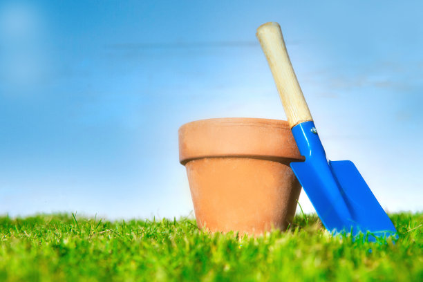 花盆空和蓝色铲在清新的绿色草地与明亮的蓝天在花园，春天，盆栽，爱好概念背景，复制空间图片下载