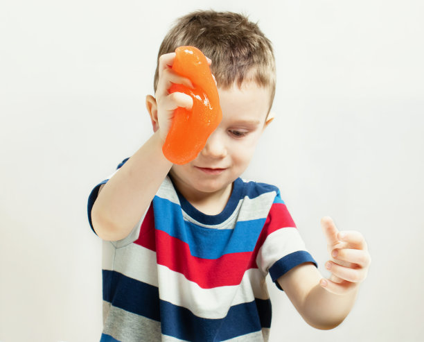 孩子玩手工制作的玩具叫做黏液。孩子们用手玩黏液玩具。使粘液。有选择性的重点图片下载