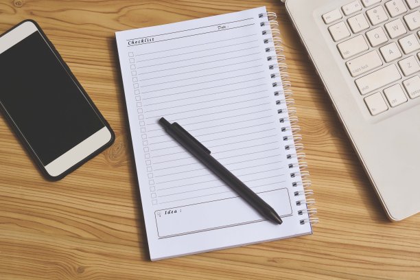 办公用品用记事本，笔记本电脑和智能手机俯视图拍摄在木桌上图片下载