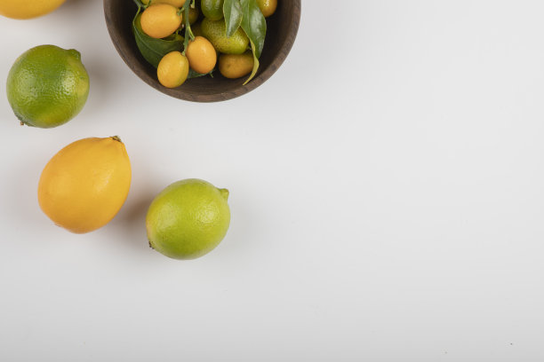 一碗新鲜的金橘，酸橙和柠檬，白底图片下载