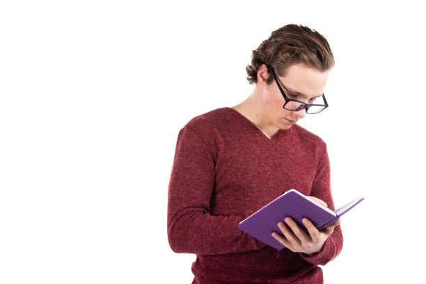 白色背景下的学生。年轻有魅力的家伙和书。图片下载