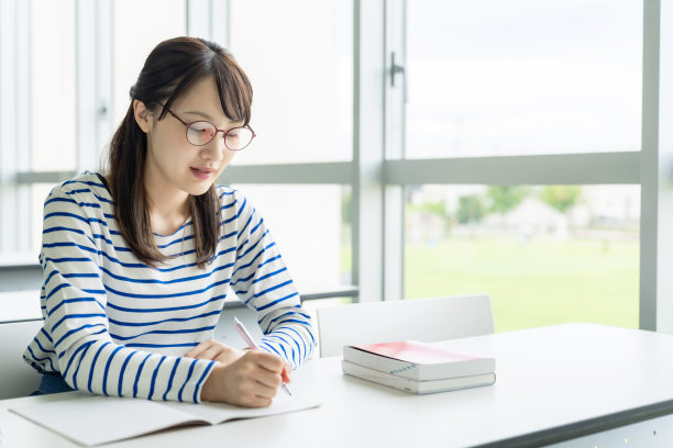 年轻的亚洲女高中生正在上课。素材图片
