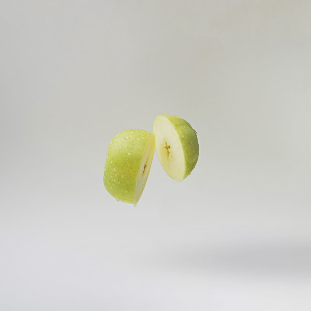 灰色背景上的切片绿苹果。最小的概念。图片下载