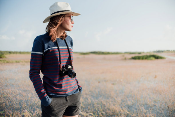 一个游客拍一个亚洲女人的概念，把相机放在她的脖子上手扒手看那边图片下载