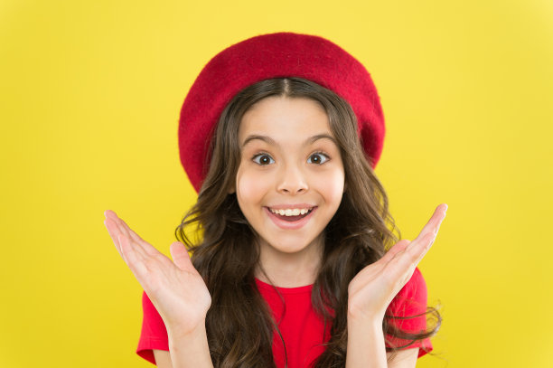 微笑的漂亮的女孩。黄色背景上的小孩，笑容可掬。小女孩开心的笑着带着美丽的神色。可爱的美丽模特可爱的微笑。我总是微笑和快乐图片下载