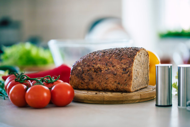 明亮的厨房里，新鲜的荞麦面包和蔬菜放在桌子上图片下载