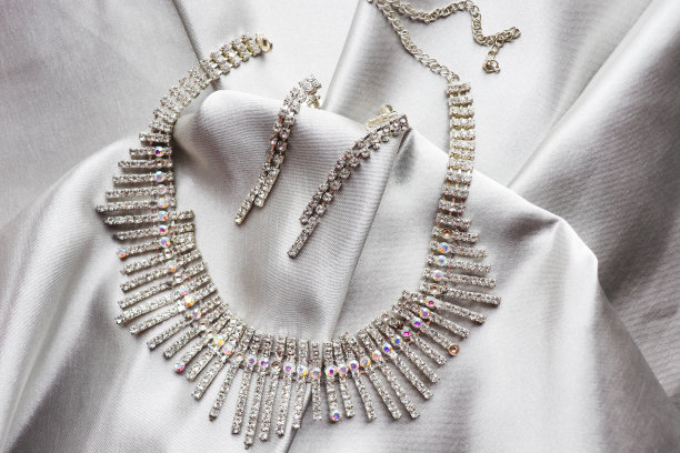 美丽的项链和耳环在丝绸的背景。女性的配件图片下载