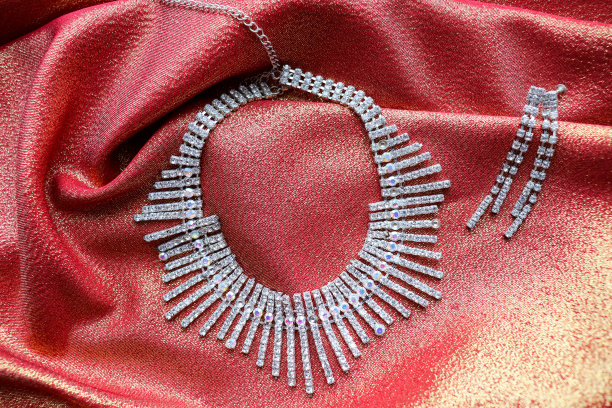 美丽的项链和耳环在丝绸的背景。女性的配件图片下载