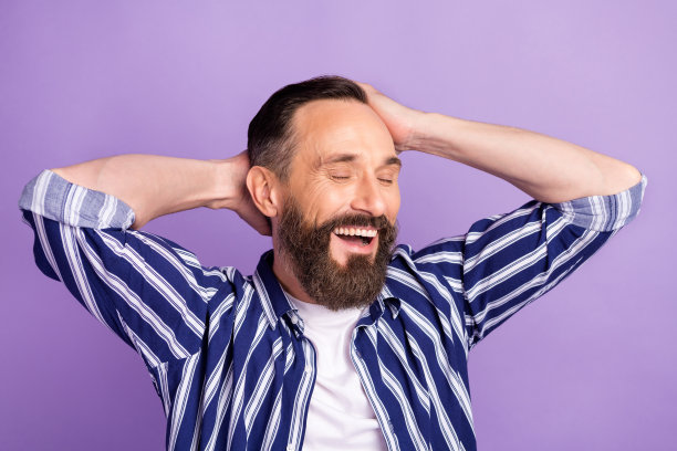 照片正面成熟的男人触摸双手，头，丝一样的洗发水洗发概念孤立在紫罗兰色的背景图片下载