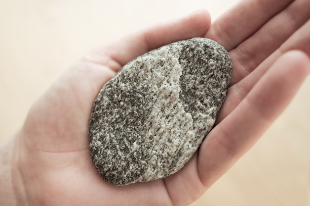 妇女拿着圆形的石头作为和谐的象征图片下载