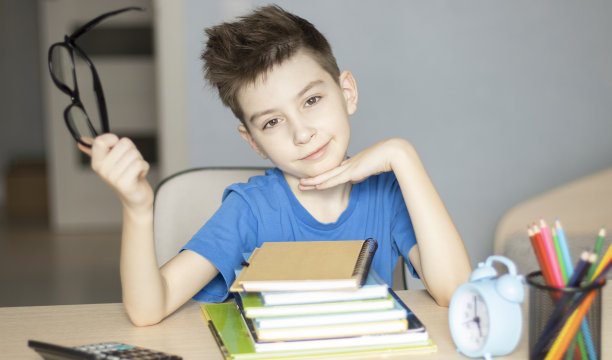 可爱的小男孩在做作业。儿童在学校学习。图片下载