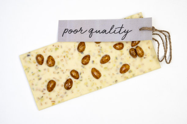 白色的背景上放着一整条香甜可口的巧克力，上面有一个小标签，上面写着“质量很差”图片下载