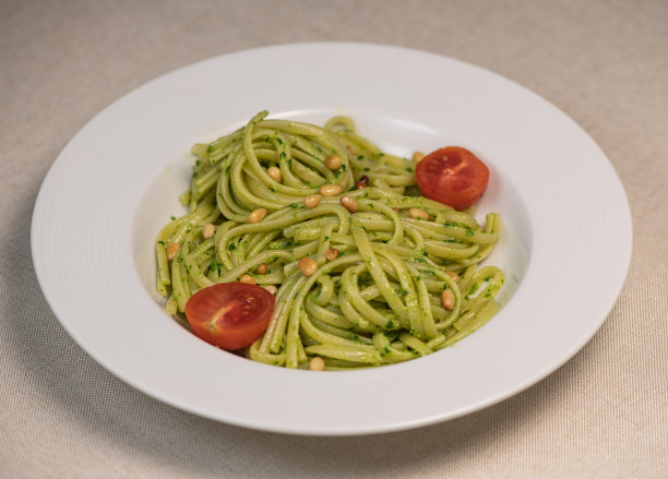 木桌上的绿色菠菜意大利面配芝士和番茄图片下载