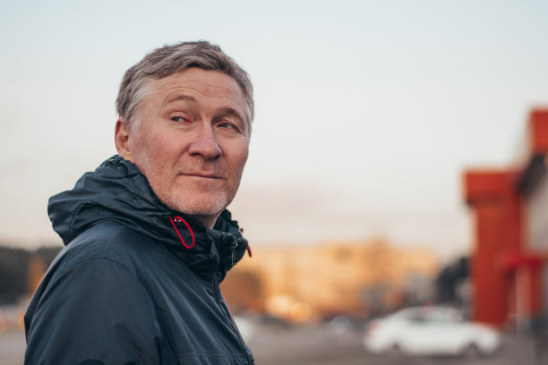 一个英俊的中年男子的肖像。一个穿着夹克的成年人在城市里。模糊的背景。本空间图片下载