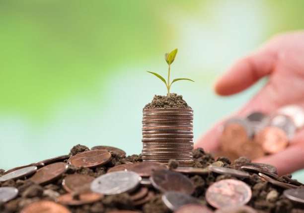 金属钱币堆在土里。图片下载