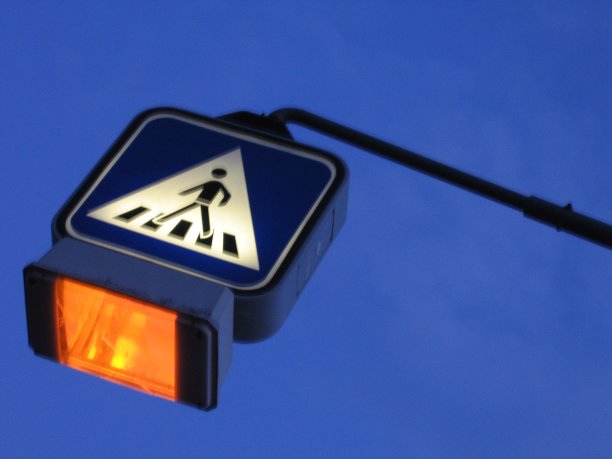 蓝天前的照明人行横道标志图片下载