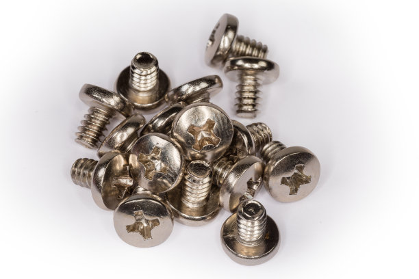 白色表面上的十字槽机器螺钉堆图片下载