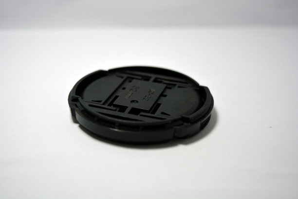 黑色塑料镜头盖放置在白色背景上。图片下载